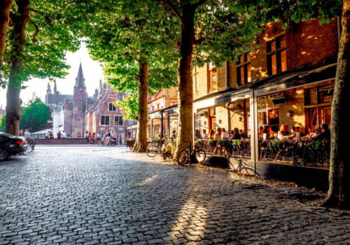 view Bruges' bridges  from a tree-lined road