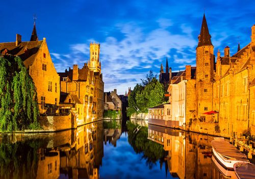 Bruges, Belgium. Image with Rozenhoedkaai in Brugge, Dijver river canal twilight and Belfort (Belfry) tower.