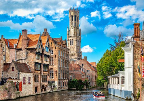 Belgium, Bruges - September 26, 2015: View from the Rozenhoedkaai in Bruges with the Perez de Malvenda house and Belfort van Bruges in the background and number of peoples in the boats.